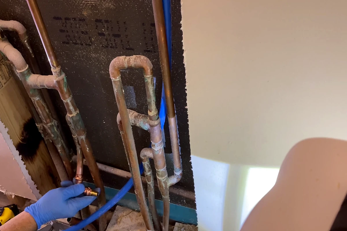 Plumber working on copper supply pipes during repiping in Ventura, CA